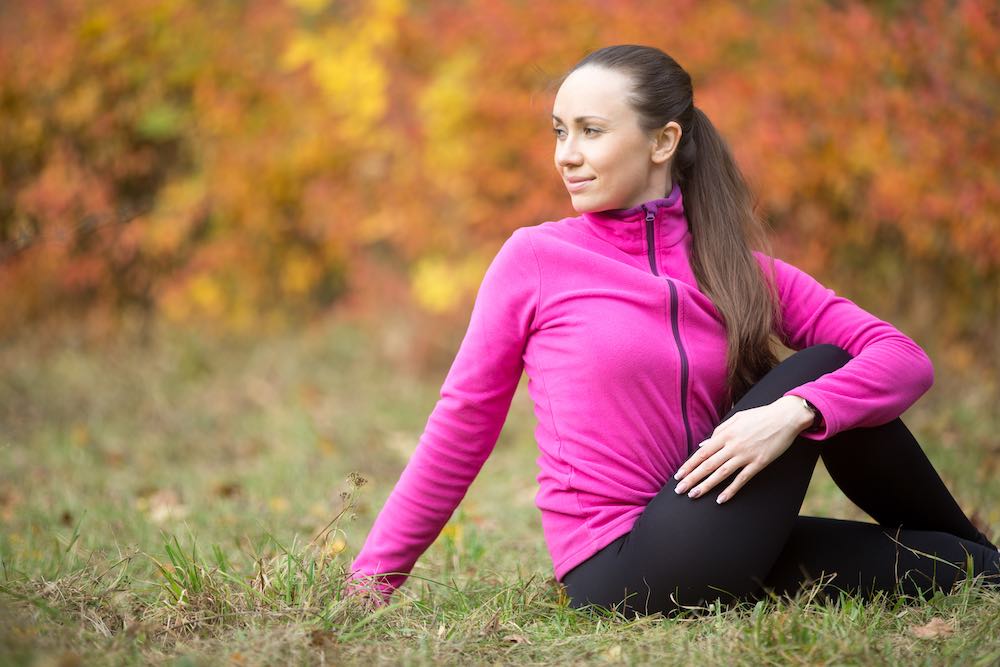 mladá žena cvičící jógu venku během podzimu