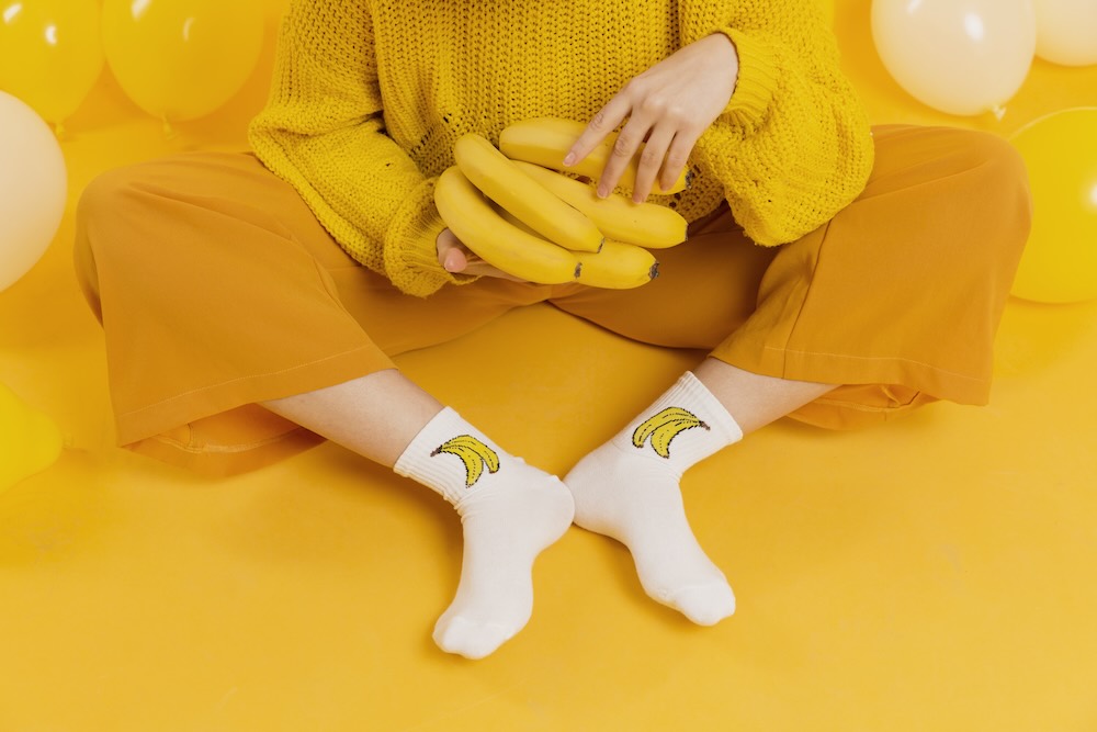 žena ve žlutém s ponožkami s motivem banánů